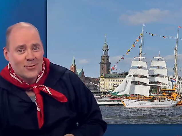 Mann begrüßt in Gebärdensprache vor Hamburg-Motiv mit Segelschiff und Michel – barrierefreier Einstieg für Gehörlose.